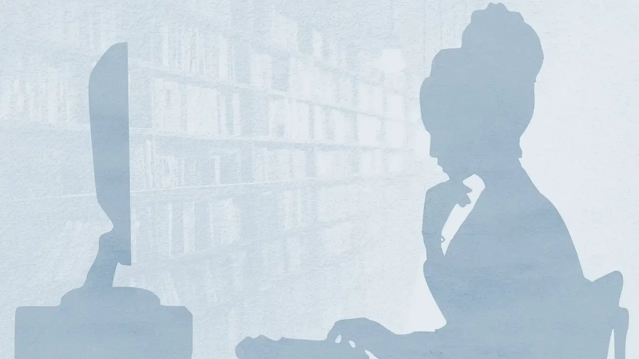 femme installée à un ordinateur devant des étagères de livres